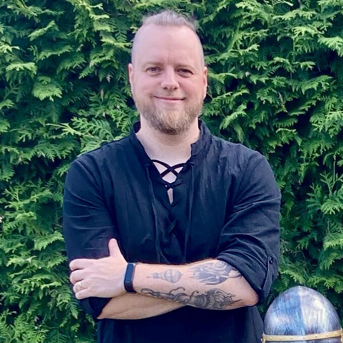 Photo of me standing in front of a hedge.